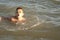 A handsome boy of 10 years old swims in the sea in different styles - on the back, breaststroke, crawl