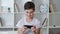 Handsome boy 13 years old playing mobile game on smartphone at home. Teenager playing mobile phone. Kid using phone for