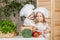 Handsome boy and beautiful young girl playing in the kitchen chefs. Healthy food. Vegetables