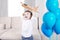 A handsome boy with joyful emotions on his face plays with toys and launches an airplane, and a set of blue balloons filled with