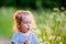 Handsome boy toddler blowing dandelion seeds in the Park