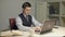 Handsome brunet man in suit and necktie typing on laptop computer at desk