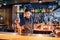 Handsome brunette barista of East Caucasian appearance preparing a drink at the bar in a restaurant. Mixing a coffee and orange