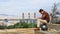 Handsome brutal stylish adult sad gentleman sitting on bench  against background of fantastic panorama of Barcelona on  Montjuic