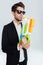 Handsome businessman in black suglasses holding colorful water gun