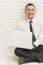 Handsome businessman relax sitting on the floor while working on