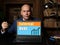 A handsome businessman showing a laptop with sign External Debt . Close-up shot. Soft focus