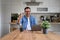 Handsome businessman showing thumbs up sign while working over laptop on desk in home office