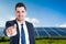 Handsome businessman with solar panels behind him