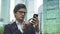 Handsome businessman swiping across his smartphone screen in Moscow city