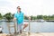 Handsome businessman on vacation with yachts on dock background. Sport Man in sunglasses laddering up on boat