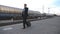 Handsome businessman walking through railway station with his luggage and talking on phone.Young business person