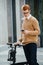 Handsome busy young man with ebike and phone on the street.