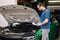 Handsome car mechanic detailed vehicle inspection. Auto service concept