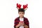 Handsome Caucasian child boy wearing deer antler hoop on head, holds a lit candle, makes a cherished wish for Christmas