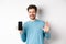 Handsome caucasian man with beard, showing empty smartphone screen and number five, raising hand to wave and say hello