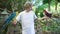 Handsome Caucasian man in white T-shirt and curly hair holds three parrots on both hands. Traveler enthusiastically