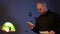 Handsome Caucasian policeman examining photos thinking standing in darkness indoors. Portrait of thoughtful man in