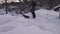 Handsome Caucasian teenager with modern wide snow sled remove snow from roof of totally snow covered house. Sunny warm day  much