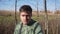 Handsome caucasian young man is walking in country side alone along fields.