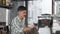 Handsome cheerful male barista preparing coffee for clients at his cafe