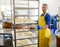 Handsome cheesemaker making curd cheese in his factory