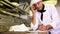 Handsome chef writing on clipboard while talking on phone