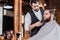 handsome confident barber shaving man