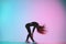 Handsome creative female dancer posing in studio against colorful background