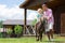 Handsome curly boy feeling excited riding horse near father