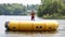 Handsome cute man jumping at a water trampoline floating in a lake in Michigan during summer.