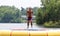 Handsome cute man jumping at a water trampoline floating in a lake in Michigan during summer.