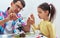 Handsome dad and cute daughter study biology and chemistry lesson with microscope. Little girl with father doing science