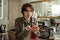 Handsome dark-haired barista enjoying scent of coffee beans