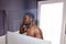 Handsome dark skineed man taking shower in bathroom