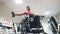 Handsome disabled man in a wheelchair raises his arms with dumbbells in the gym during training.