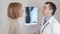 Handsome doctor talking with his patient for the annual check-up in the hospital. Woman smiling