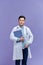 A handsome doctor wearing white lab coat and stethoscope smiling friendly and posing with his folder