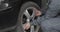 Handsome driver unscrewing car wheel by pneumatic wrench on roadside to replace flat tyre on roadside. Man in casual