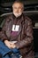 Handsome elderly man in glasses and leather jacket close-up