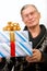 Handsome elderly man holding gift boxes