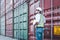 Handsome Engineer worker foreman wears personal protective equipment hardhat one hand holding cargo container cover and clipboard