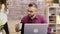 Handsome entrepreneur taking a sip of coffee while working on laptop