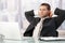 Handsome executive sitting at desk stretching