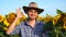Handsome farmer man is showing OK gesture in a sunflower field. Agriculture and nature concept