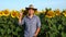 Handsome farmer showing victory sign on sunflower field, Young man showing peace sign outdoors