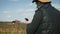 Handsome farmer with smartphone standing in field sunflower with combine harvester in background. Concept modern