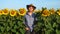 Handsome farmer in a sunflower field. Young farmer man in hat is standing in a sunflower field.