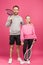 handsome father and daughter holding tennis rackets and ball, isolated