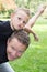 Handsome father piggy back with young son child boy outdoor home garden